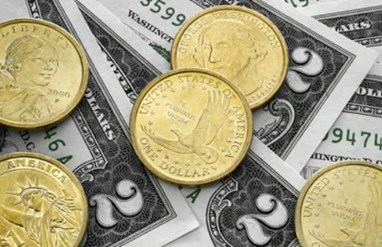 Close-up of US one-dollar coins and bills scattered, highlighting American currency